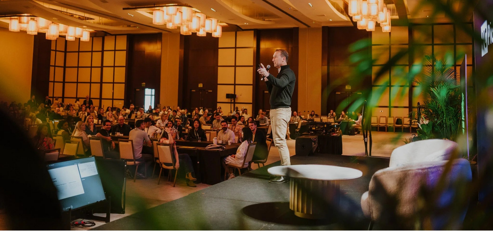 Edward giving a presentation in a large, well-lit conference room with attendees.